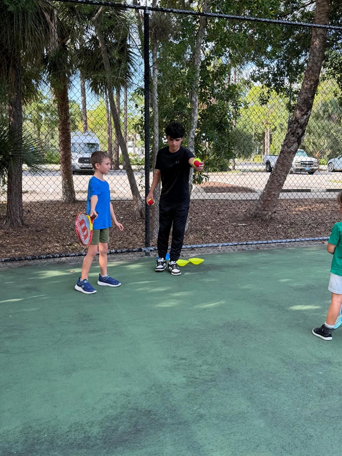 Tennis instructor teaching kids on court